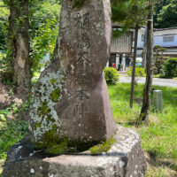 「樋橋茶屋本陣跡」。かぎ手が国道に切断された三角形の跡地に建つ。下諏訪コミュニティバス「あざみ号」のバス停がある。