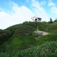 殿ヶ池の北西に建つ立派な避難小屋。その下の池はおひねり池、権現の御池とも呼ばれました。