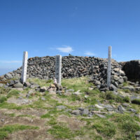頂上標柱の後の石垣の中に大汝神社が鎮座
