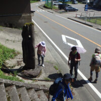 国道脇の階段横に立つ石は籠の渡しの藤綱を結んだ石といわれている