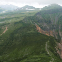 獅子岳からザラ峠 獅子岳からザラ峠への下りで南を見る。五色ヶ原の手前鞍 部がザラ峠、その右が立山カルデラ、左が中ノ谷。左奥に 薬師岳。