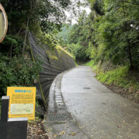 南郷往還西の入口：外牧神社のすぐ東脇から、外輪山の西に張り出す尾根 を東に向かって徐々に高度を上げていく。 (大津町教育委員会の案内標識)