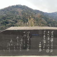 かつて戸下温泉があった黒川と白川の合流点：阿蘇山麓温泉として一世を風靡した戸下温泉であるが、立野ダムの計画に伴い閉鎖され今は更地となり長陽大橋の橋脚が立つ。黒川の流れが白川の流れにＴ字形にぶつかる ように合流している。合流点には熊本地震で崩落した岩が半ば白川の流れを塞いでいる。(長陽大橋脇に建つ歌碑)
