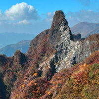 根子岳天狗岩の峰：根子岳最高峰天狗岩。中央の白く見える部分は2016年の熊本地震で崩落した跡。根子岳は紅葉の名所でもある。